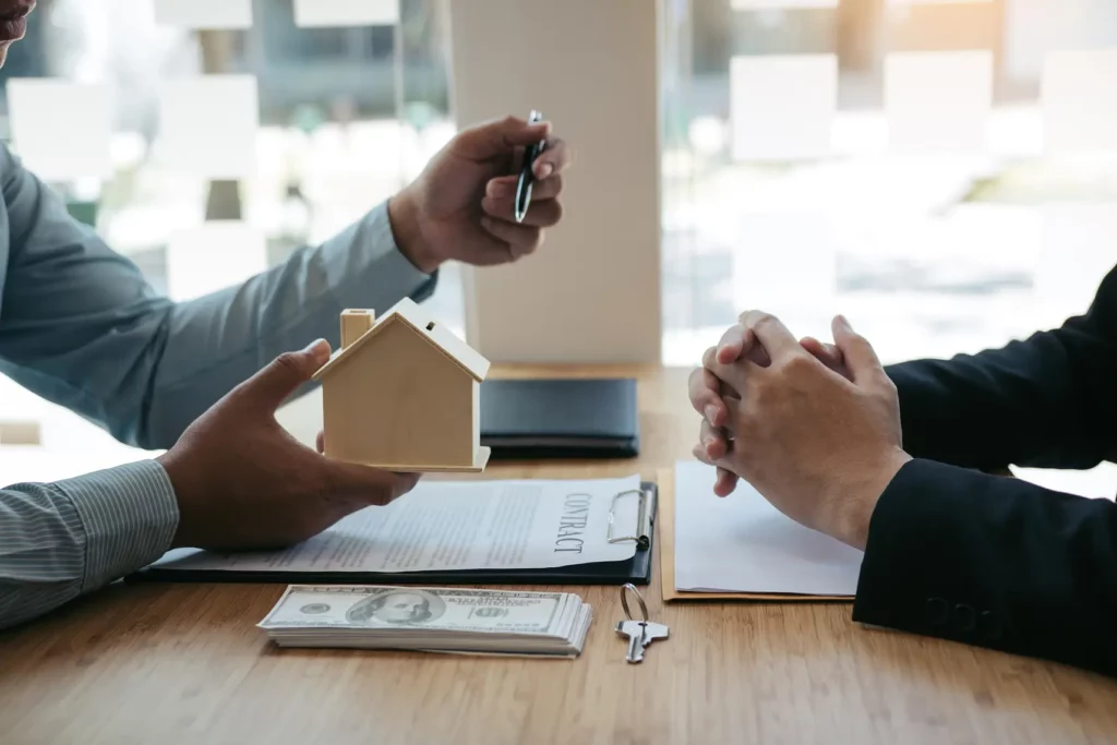 transaction immobilière avec maquette de maison et argent